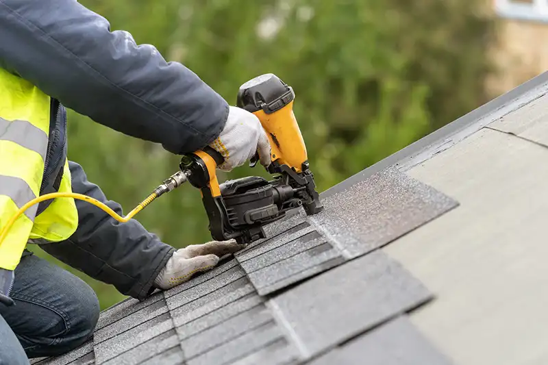 Roofing contractor securing comporition tiles on a roof